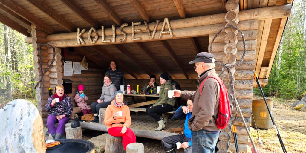 Kyläläisiä Kolisevan laavun tulipaikan äärellä kahvilla.